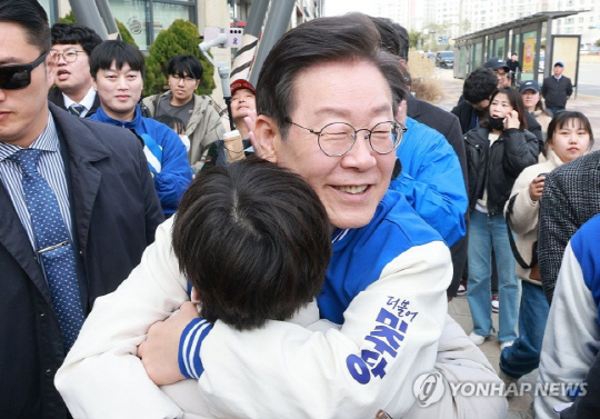 이재명 더불어민주당 대표가 17일 오후 경기도 화성시 동탄호수공원 인근에서 한 아이와 포옹하고 있다. <연합뉴스>